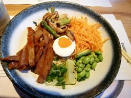 barbecue-glazed seitan served with a coconut + sriracha vegan egg, grilled shiitake mushrooms and asparagus on a bed of brown rice. topped with edamame beans, carrots and spring onions. dressed with a sweet amai sauce and garnished with sesame seeds and fresh lime //20 Sumner Street, London SE1 9JZ England